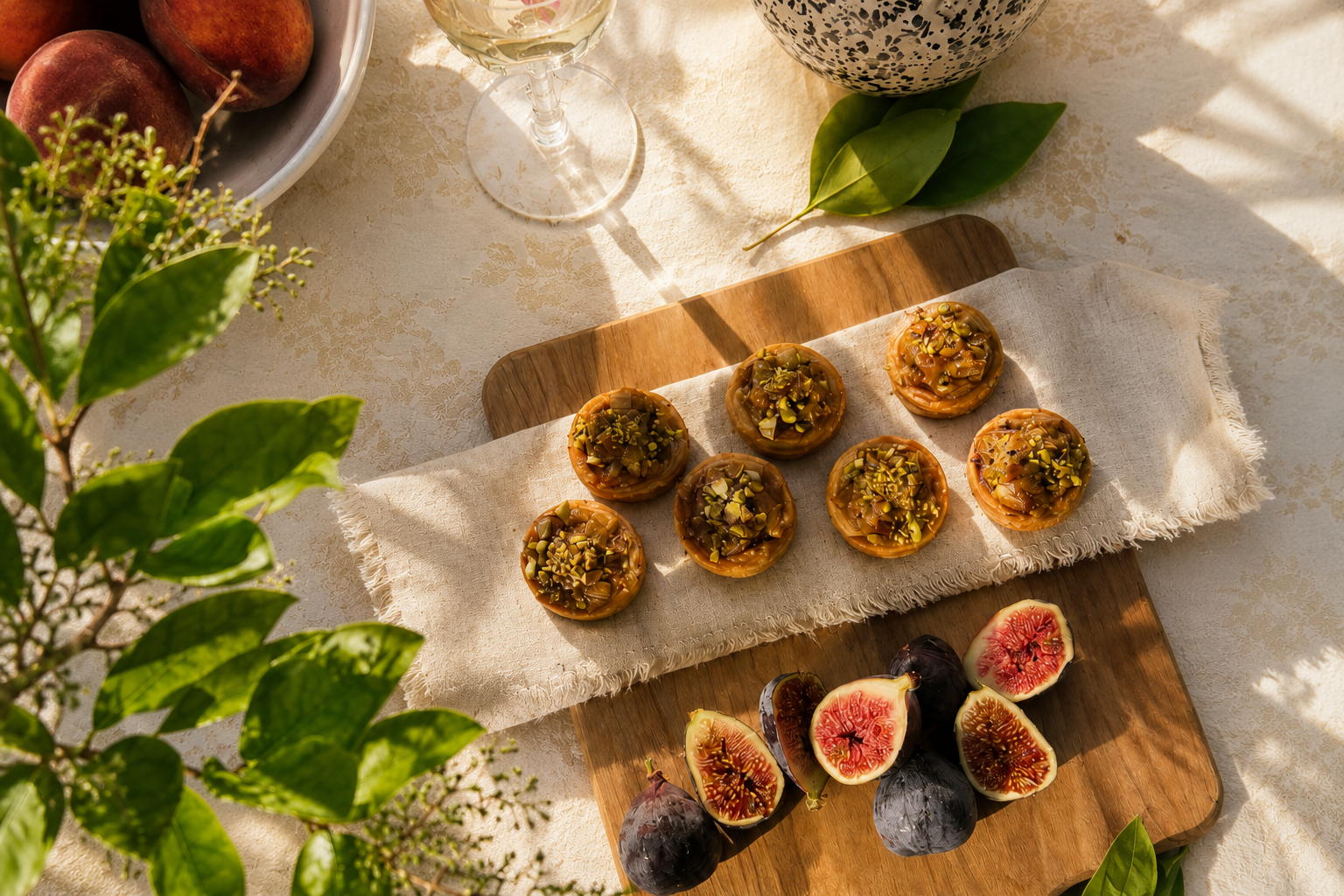 Fig tartlets arranged on a wooden board with fresh figs and wine